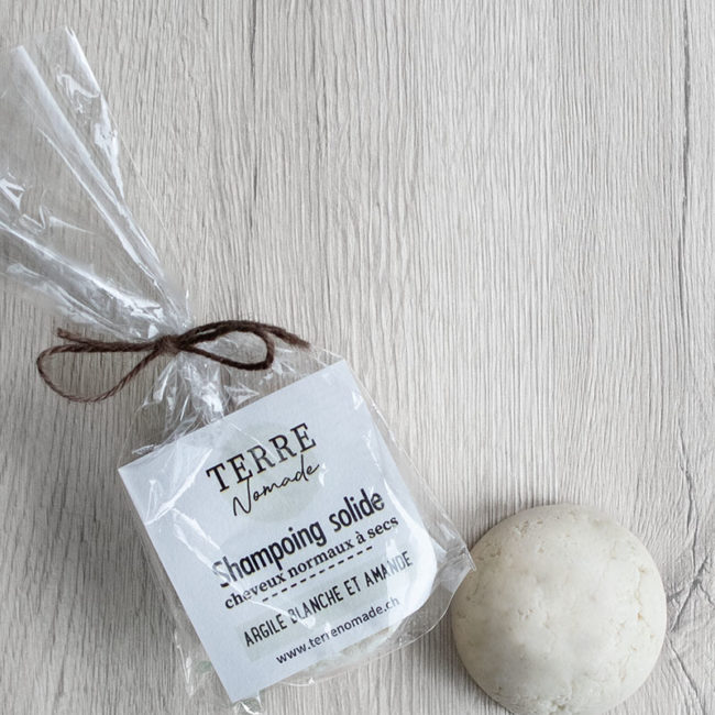 Sachet en bioplastique et shampoing solide à l'argile blanche et à l'huile d'amande douce fabriqué à la main par Terre Nomade.